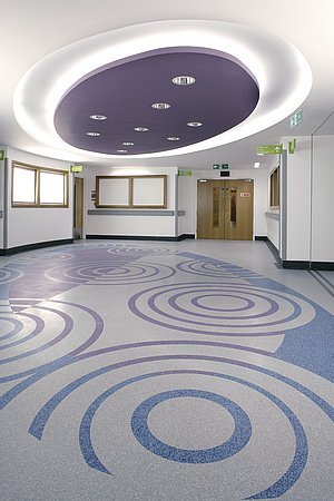 Rozkreslený návrh vzhledu podlahy a realizovaná podlaha v britské nemocnici v Romfordu (technologie Floorcraft)