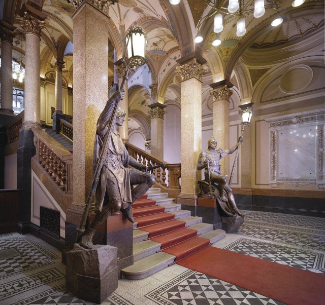 U paty schodiště jsou dvě velké bronzové sochy Světlonošů od Bohuslava Schnircha