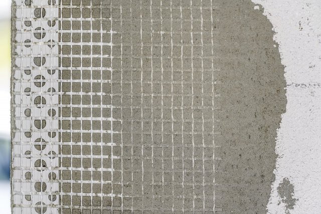 Základní vrstva sestává z tenké penetrační vrstvy stěrkové malty nanesené na izolant, na níž je aplikována další vrstva malty. Do té je vkládána výztužná síťovina. Foto: Lubo Ivanko