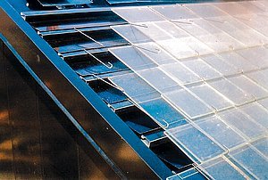 Obr. 4: Firma American Solar nabízí solární systém ohřevu, který využívá techniku jednoduché a velmi rozšířené skládané střešní krytiny k realizaci slunečního kolektoru o velké ploše za nízkou cenu. Sluneční záření prochází systémem průsvitných střešních tašek a ohřívá tmavě zbarvené pásy kovového absorbéru. Když se vrstva absorbéru ohřeje, teplem od ní se ohřívá vzduch pod taškami, který se používá pro vytápění. Vyšším stupněm je řešení, kdy jsou do vrstvy absorbéru integrovány trubky pro ohřev teplonosné kapaliny, systémově pospojované do cirkulačního okruhu pro ohřev vody.