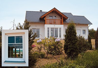 Obr. 2: Pohled na východní bok domu z obr. 1 z boku. Pokud si zákazník nepřeje jinak, je pro domy WH standardně dodávána pálená střešní krytina ERLUS, která je patrná na obrázku. Ve výřezu je pohled na okno zn. BAYERWALD. Tmavě modrý odraz oblohy v okně a nažloutlý průzor na krajinu za domem je typický pro termoreflexní úpravu okenního zasklení.