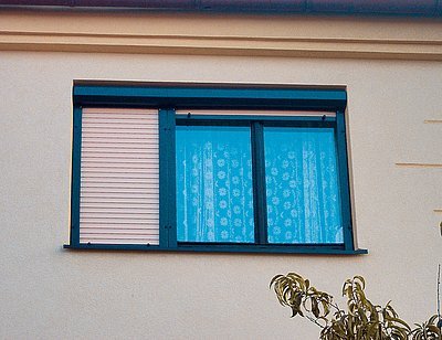 Okno ve tvaru typickém pro 70. léta minulého století. Majitel okno opatřil předokenní žaluzii, která je nejúčinnější ochranou před vysokými tepelnými zisky v létě a v zimě před tepelnými ztrátami.