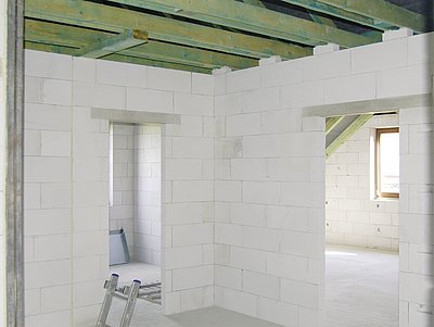 Světlé čisté stěny z pórobetonu opticky zvětšují místnosti hrubé stavby.