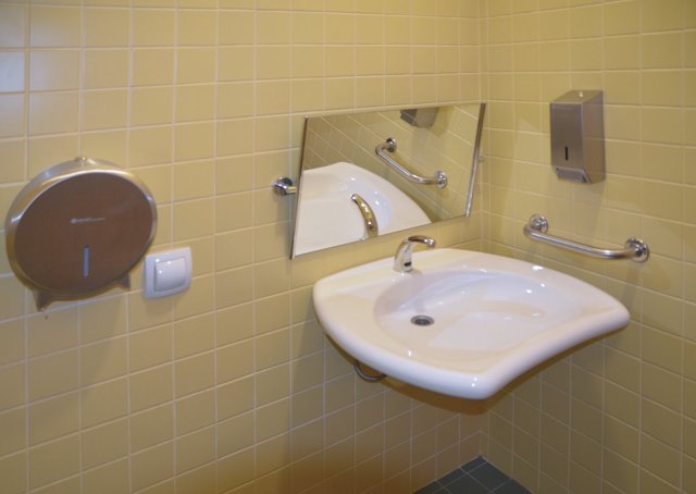 Toaleta pro invalidy ve Studijní a vědecké knihovně v Hradci Králové je vybavena nerezovým programem (madlo, zásobník na mýdlo a zásobník na toaletní papír)