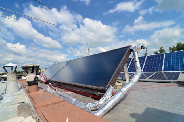 Termické panely pro ohřev TV a v pozadí fotovoltaické panely pro výrobu elektrické energie