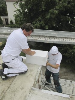 Usazení první rohové tvárnice (Ytong Theta 499 mm) vyžadovalo pozornou přípravu. Vyložení této tvárnice cca 13 cm za okraj přízemního patra bylo z důvodu zateplení spodní části budovy. Nově zbudované patro bude pak bez zateplení.