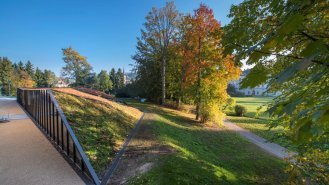 Pohled na čelní stěnu s hlavním vchodem a zámkem v pozadí