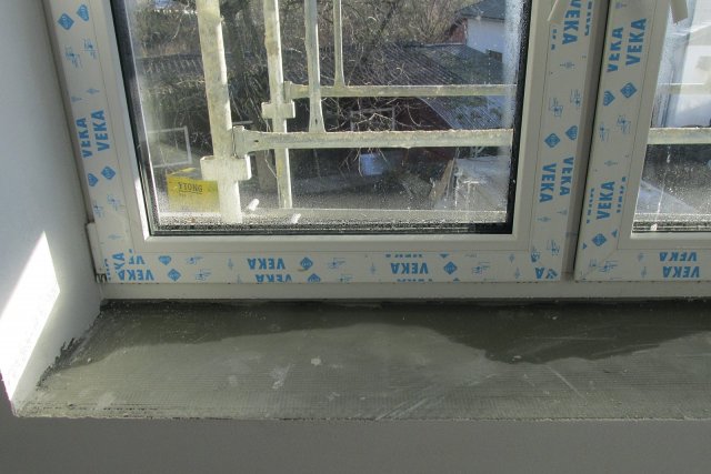 Pohled na čerstvě zabudované okno v novostavbě s vysokou vlhkostí, říjen 2015 ráno. Je patrné, že se rosí nejen zasklení (trojsklo) na vnitřní straně v dolní části okna, ale ještě více plocha křídla a rámu okna, jejichž izolační schopnost je mírně horší, než u trojskla. Vznikající kondenzát skapává na parapet. V místnosti o běžné relativní vlhkosti cca 50 % by k vnitřnímu rosení nedošlo.