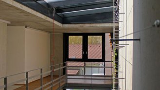 Detail betonové stěny &ndash; budoucí zelení popnuta stěna, osvětlená střešním oknem