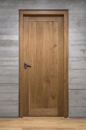 Masivní dubové dveře efektně doplňují současné interiérové trendy využívající betonu jako základního prvku. (Autor: marvic, Shutterstock) 