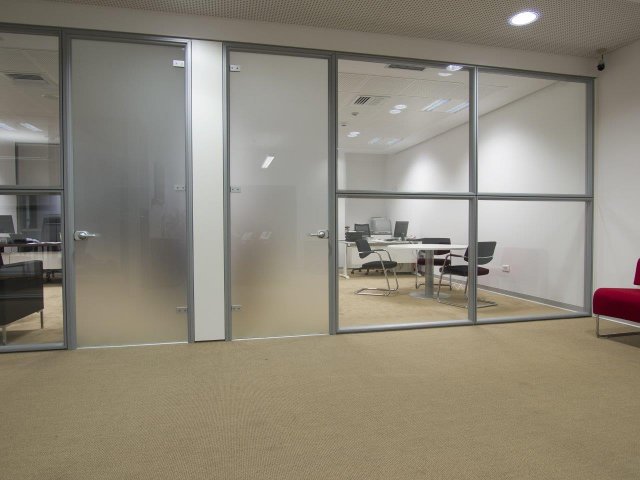 Skleněné dveře se výborně hodí do kancelářských prostor jako součást celoskleněných příček, které oddělují například zasedací místnosti od otevřených pracovních prostor. Akustická izolace je zajištěna, zatímco žádoucí průhlednost je zachována. (Autor: Basileus, Shutterstock)