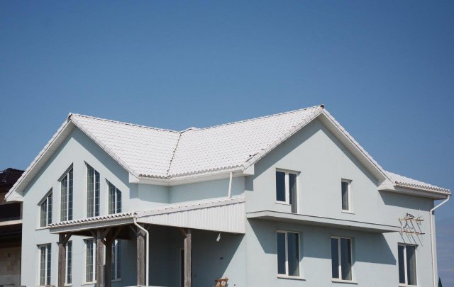 Bílá střecha výrazně vylepšuje vnitřní klima v domě, protože účinně odráží velké procento slunečního záření. (Autor: Radovan1, Shutterstock)
