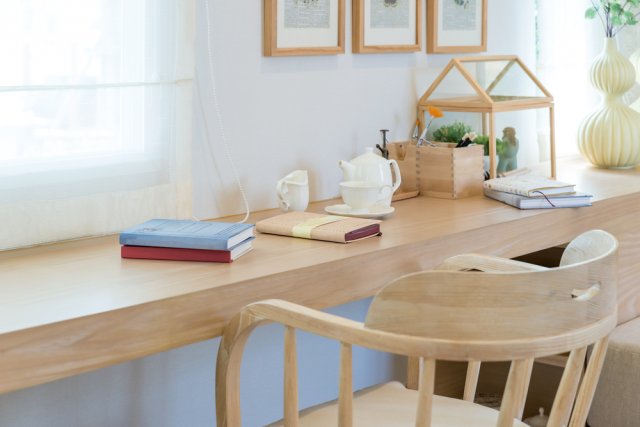 Stůl na obrázku je dostatečně velký, aby plnil funkci pracovní, odkládací i dekorační. Především je však velmi správně umístěn tak, aby na něj dopadalo co nejvíce přirozeného světla. (autor: Prasit Rodphan, Shutterstock)