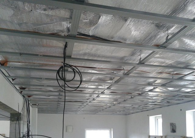 Stropní zavěšený křížový rošt pro sádrokartonový strop je velmi vhodný pro zavěšení panelů nízkoteplotního stropního vytápění. Reflexní fólie, která je umístěna cca 15 cm nad budoucími topnými panely, bude významně bránit úniku tepla do stropu a ven