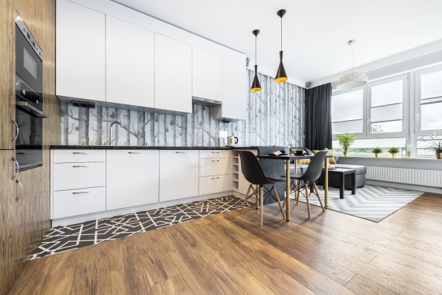 Dřevěné podlahy patří k nestárnoucí klasice a jsou ideální do otevřených prostor, kdy kuchyně přechází do obývacího pokoje. Zdroj: Cinematographer, Shutterstock