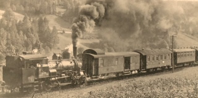 Dobová fotografie zachycuje jízdu parního vlaku na trati Tanvald-Kořenov.