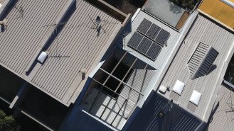 Pohled na střechu objektu s fotovoltaickými panely.