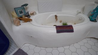 Jak sprchový kout, tak vana jsou vyzděny, aby kopírovaly oválný tvar koupelny