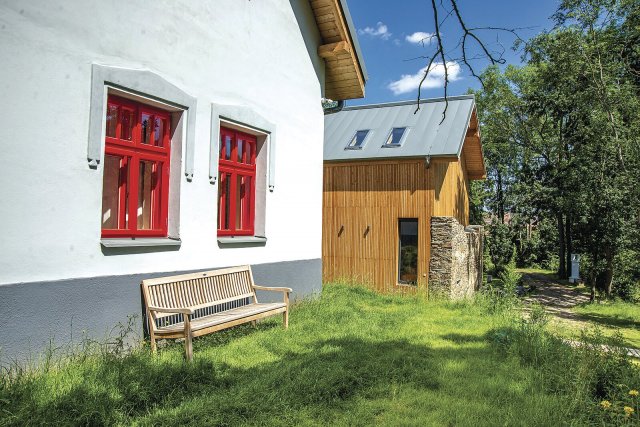 Červená okna jsou replikami původních otvorových výplní. Okolo nich byly obnoveny dekorativní šambrány.Foto: Jan Vítek, archiv samoty Hojšín