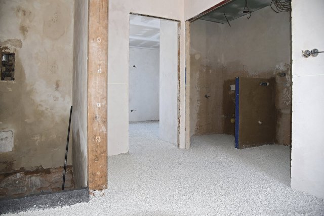 Rekonstrukce a modernizace rodinného domu v Třešti: Pohled na část lité tepelné izolace ThermoWhite v přízemí domu krátce po její realizaci. Po vyzrání podlahy (tj. po vytvrzení tekutého lepicího pojiva mezi buňkami recyklovaného EPS, což trvá přibližně den) lze realizovat finální podlahou krytinu.