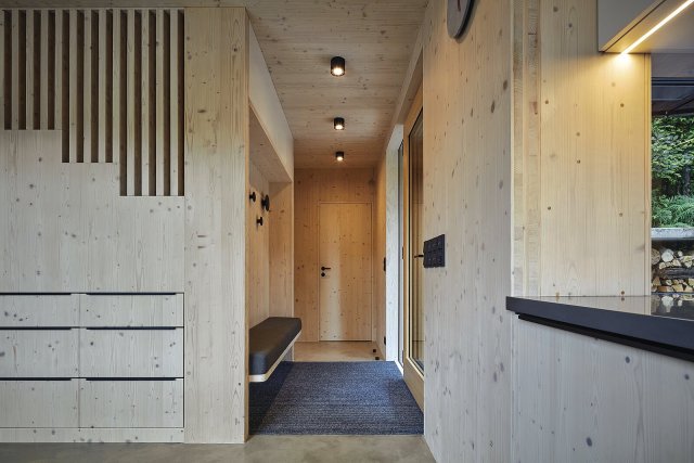 Interiérové stěny tvořené smrkovým dřevem (masivními CLT panely) vytvářejí útulné útočiště.