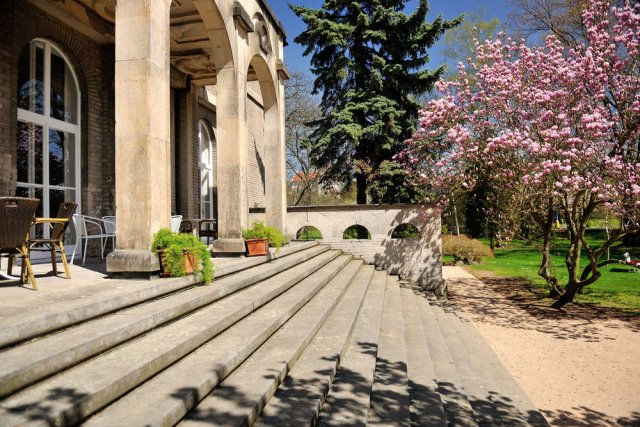 K efektním prvkům patří široké schodiště vedoucí do zahrady, jejíž součástí je i velký dekorativní bazén, v jehož rozích bývaly umístěny kovové žáby jako chrliče vody. 