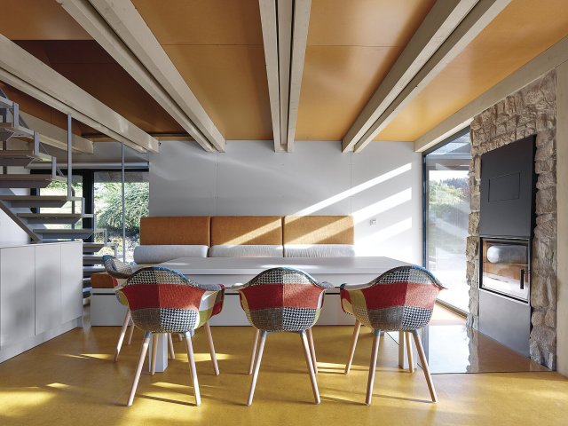 Stěny v přízemí jsou z interiérové strany obloženy světlými HPL deskami, které doplňuje
oranžové marmoleum na podlaze.