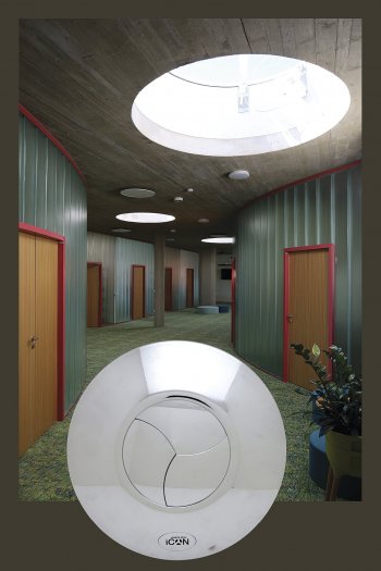 Namísto běžného ventilátoru se jedná o designový kruhový disk s třílistou clonou, která se při zapnutí otevře a po vyvětrání opět sama zavře. Na pozadí fotografie prostor Gallaudet centra.