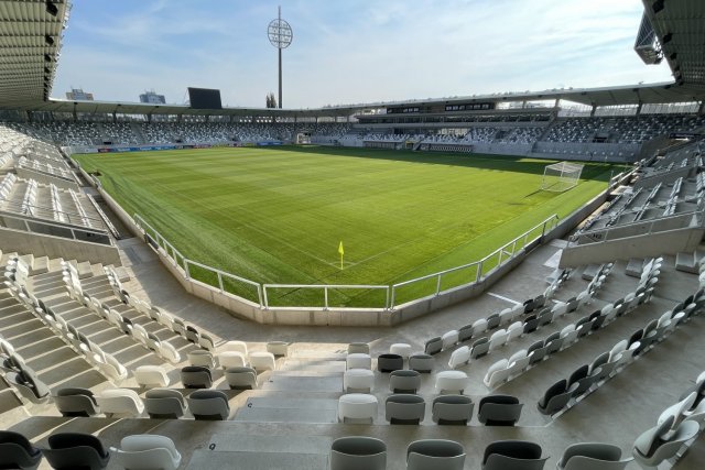 Sedačky jsou navrženy v bílé, šedé a tmavé šedé barvě. Nad každou z branek visí dvě velké LED obrazovky.
Zdroj: archiv FC Hradec Králové, a.s.