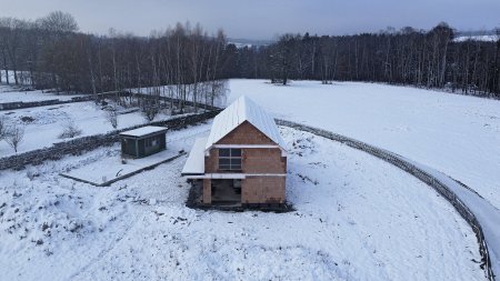 Dům čeká ještě mnoho stavebních prací, zatím je hotová hrubá stavba, která přečkala pod zafóliovaným krovem zimu.