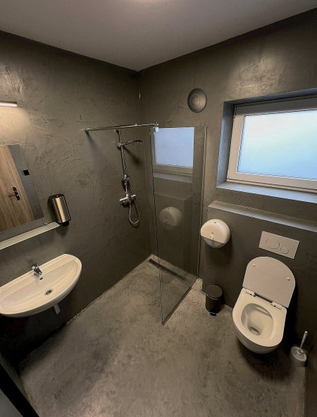 V upravených koupelnách Kempu Brdy neunikne pozornosti působivý kruhový disk s třílistou clonou na stěně (na snímku vlevo od okna). Jde o designový ventilátor iCON, honosící se světovým „Oskarem“ za design – proslulou cenou Red Dot Design Award. Foto: Kemp Brdy, www.kempbrdy.cz