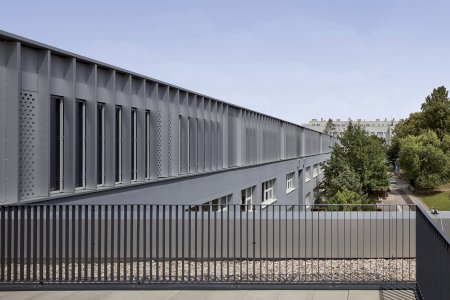 Stínící lamely dodávají fasádě nástavby prostorovou dynamiku kontrastující s robustními liniemi původních dvou podlaží.