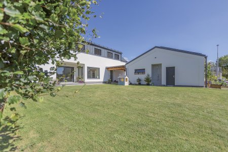 Vikýře v podkroví jsou obložené hliníkovým plechem. Garáž s dílnou plynule navazuje na dům.