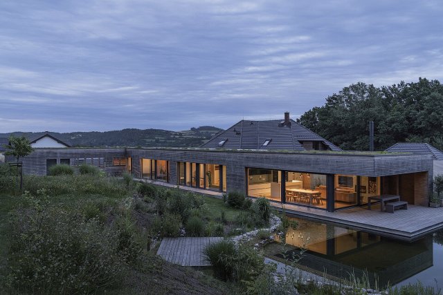 Dům ve tvaru písmene L chytře využívá mírného svahu a na ploše přes 250 m2 nabízí pět obytných místností, dvě koupelny, šatnu a velkorysý obývací prostor s kuchyní a jídelnou. Autor: Petr Polák, petrpolakstudio.cz