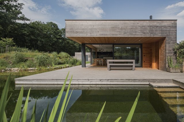 Voda je dominantou celého místa. Koupací jezírko navazuje přímo na obytnou část a přináší pocit, že hladina je součástí obývacího pokoje. Autor: Petr Polák, petrpolakstudio.cz