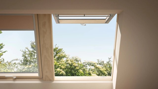 Výklopně-kyvné střešní okno VELUX otevírá interiér směrem ven a posiluje propojení podkroví s okolní krajinou.