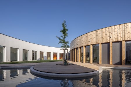 Fasáda hospice odráží inspiraci zahraničními stavbami, které kladou důraz na propojení s přírodou a použití přírodních materiálů. 