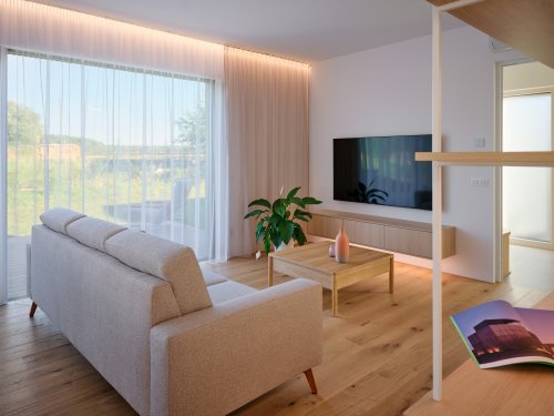 Dřevo nezůstává jen na fasádě. Přirozeně pokračuje i v interiéru, kde se objevuje na podlaze, nábytku a dalších detailech.