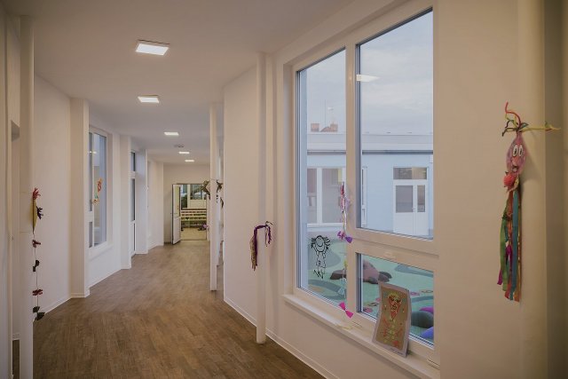 Nové spojovací krčky působí svěže a vzdušně. Velká okna zajišťují dostatek denního světla a výhled na dětské hřiště, stěny zdobí veselé výtvory dětí.