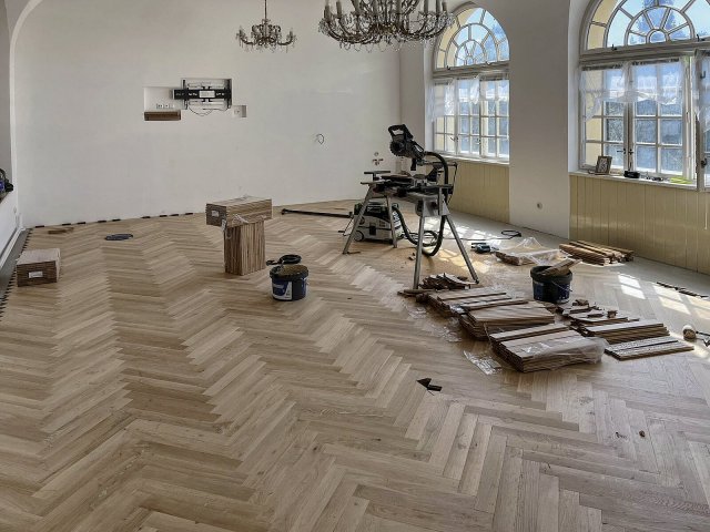 Masivní dubové parkety 22 × 75 × 500 mm byly kladeny do stromečku. K lepení sloužilo prémiové parketové lepidlo UZIN MK 200.