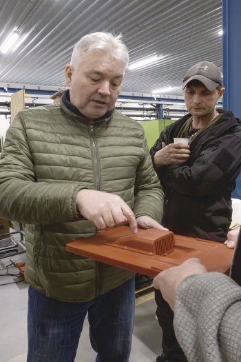 Na školení se přišel podívat pan Vinkler starší, který řekl něco z historie vzniku střešní tašky SOLAR a ukázal na ní detaily činící ji unikátní. Na obrázku je vidět prostup, který je možno využít pro větrání či například pro kabeláž nutnou pro zabudovávání fotovoltaiky.